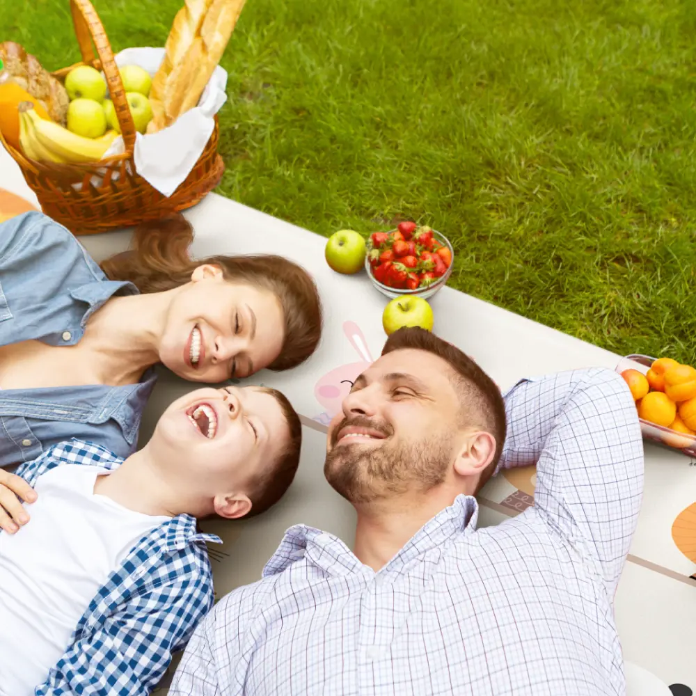 Family relaxing on a Dwinguler premium playmat outdoors