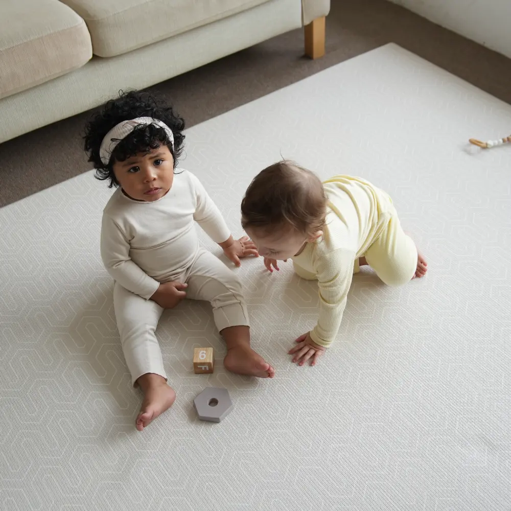 Two children playing on a Dwinguler premium foam playmat